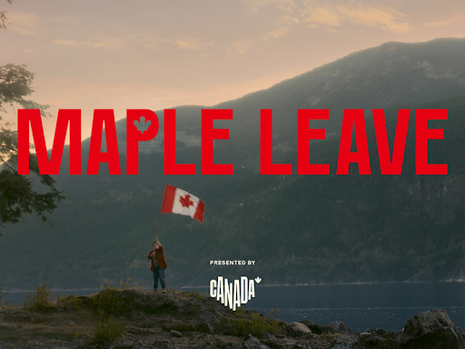 A person stands on a rocky shoreline holding a waving Canadian flag, with a scenic backdrop of a lake and mountains at sunset. The bold red text "MAPLE LEAVE" is displayed across the image, with "Presented by Canada" written below.