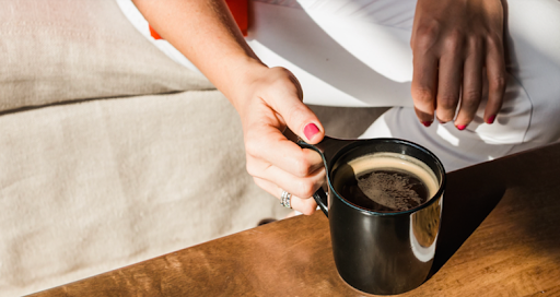 A person sits on a beige couch, as they relax after participating in Lexington’s Pick Up Perks program, which rewards litter cleanup with a free cup of coffee.